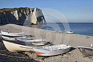 Small boats on pebble beach of Etretat in France