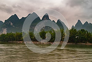 Small boats at steps in front of karst mountains along Li River in Guilin, China