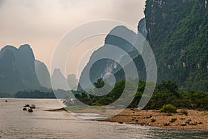 Small boats among tall karst mountains on Li River in Guilin, China