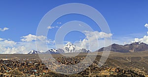 Small Bolivian village under snow mountains