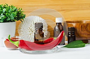 Small bottle with red chili pepper tincture and fresh chili pepper for preparing homemade healing hair mask