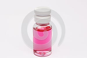 Small bottle with red liquid inside. Red colored fluid. photo