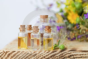 Small bottles with essential oils on wooden table. Alternative medicine concept