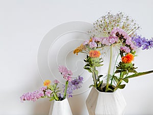 Small bouquet of wild spring flowers in faux marble vases