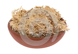 Small bowl filled with shredded slippery elm bark isolated on a white background side view