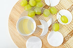 Small bowl with grape seed oil (grape juice, vinegar) and cotton pads. Diy facial mask, face toner.