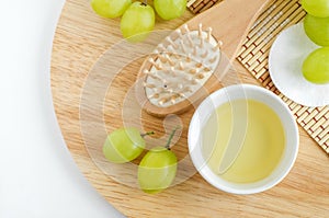 Small bowl with grape seed oil, grape juice or vinegar, cotton pads and wooden hair brush.