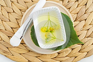 Small bowl with homemade linden (tilia, basswood, lime tree) face toner with linden flowers. Natural beauty treatment