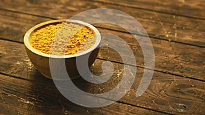 Small bowl of orange turmeric spice