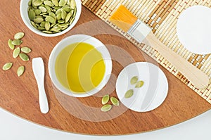 Small bowl with pumpkin seed oil. Natural autumn beauty treatment and spa recipe. Top view