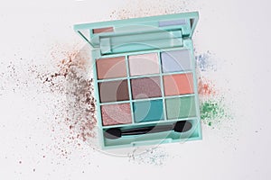 A small box of eyeshadow colors with an application brush photo