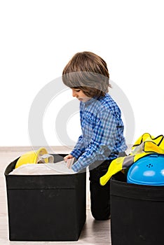 Small boy arrange things in boxes photo