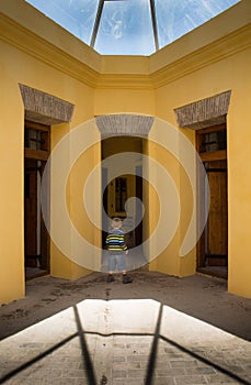 Small boy in awe at entrance of ancient jail cells