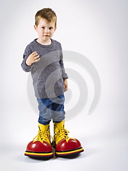 Small boy with big clown shoes