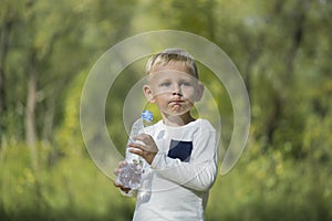 A small boy with a bottle of still water