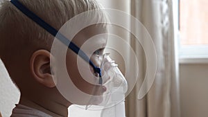 A small boy child, when coughing, infectious bronchitis of the disease breathes into the inhaler in order to recover for prevent