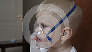 A small boy child, when coughing, infectious bronchitis of the disease breathes into the inhaler in order to recover for prevent