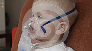 A small boy child, when coughing, infectious bronchitis of the disease breathes into the inhaler in order to recover for prevent