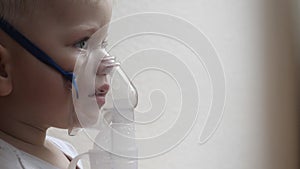 A small boy child, when coughing, infectious bronchitis of the disease breathes into the inhaler in order to recover for prevent