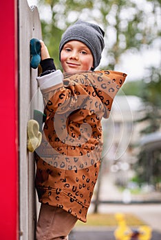 Small boy climbing a rock wall at playground