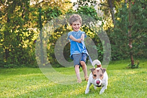 Small boy and dog training to walk on leash without pulling