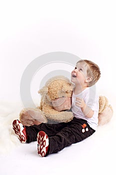 Small boy embraces plush bear