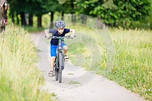 Small boy in helmet riding bicycle in park