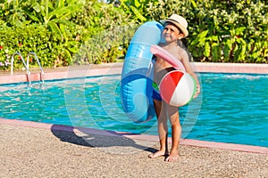 Small boy with inflatable ring, ball, pool noodle