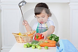 Small boy in kitchen apron with ladle and photo