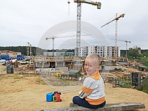Small boy looking on building construction. Future houses concept