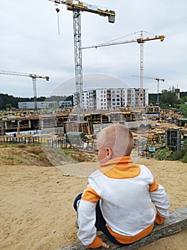 Small boy looking on building construction. Future houses concept