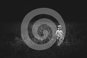 Small boy in the middel of a field in black and white photo