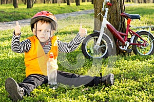 Small boy out riding giving a thumbs up