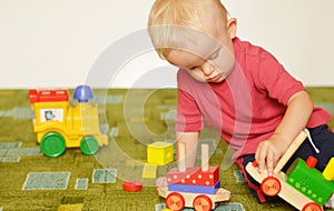 Small boy is playing with trains