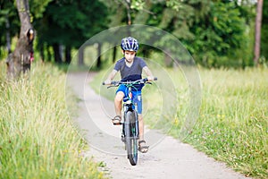 Small boy in helmet riding bicycle in park