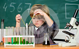 Small boy at science camp. microscope at lab. Scientific experiment. Pupil looking through microscope. student do