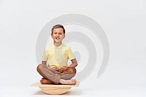 Small boy is sitting on a special simulator for training vestibular apparatus