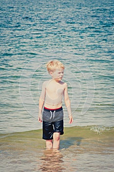 Small boy walking in the sea