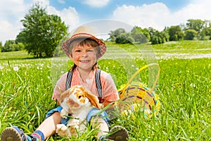 Small boy wearing hat and hugging rabbit