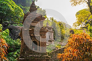 A small brick Pagoda at Bich Ding in Tam Coc, Vietnam with the sun shining behind it during a beautiful sunrise