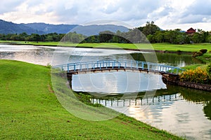 Small bridge in golf course green grass field and lagoon