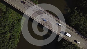 A small bridge over the river. Clip. The view from the drone. A narrow river through which there is a high bridge on