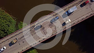 A small bridge over the river. Clip. The view from the drone. A narrow river through which there is a high bridge on photo