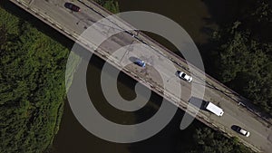 A small bridge over the river. Clip. The view from the drone. A narrow river through which there is a high bridge on photo