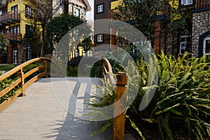 Small bridge before shady exotic buildings at sunny winter noon