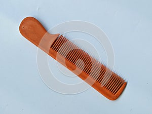 Small brown hair comb on plain white paper