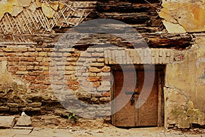 Small brown wooden door in brick wall