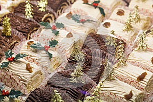 Small buches de NoÃ«l with gold decorations at pastry shop