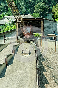 Small bucked loader of gravel stone in pavement industry retro style vertical image