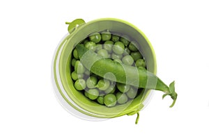 A small bucket contains a bunch of green peas with one green pea pod